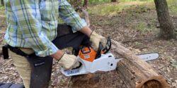 A man demonstrating proper chainsaw safety while cutting a log.