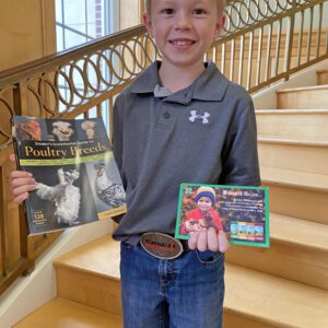 Jesse Knight with his book and feed coupons, which were his prizes for winning second place in the Golden Egg Contest.