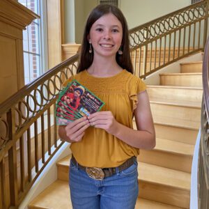 Elizabeth Knight with her feed coupons, which were her prizes for winning third place in the Golden Egg Contest.