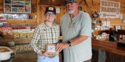 Eleven-year old Desper Dobbs sells his Desper's Dozen brand eggs at Reeves Peach Farm in Hartselle. Desper is pictured with farm owner Mike Reeves.