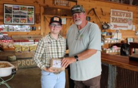 Eleven-year old Desper Dobbs sells his Desper's Dozen brand eggs at Reeves Peach Farm in Hartselle. Desper is pictured with farm owner Mike Reeves.