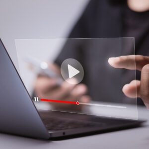 A person sitting at a laptop with a virtual video screen for webinars in front of them.