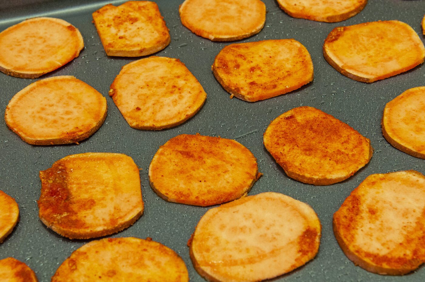 A pan of sweet potato slices to bake for chips.