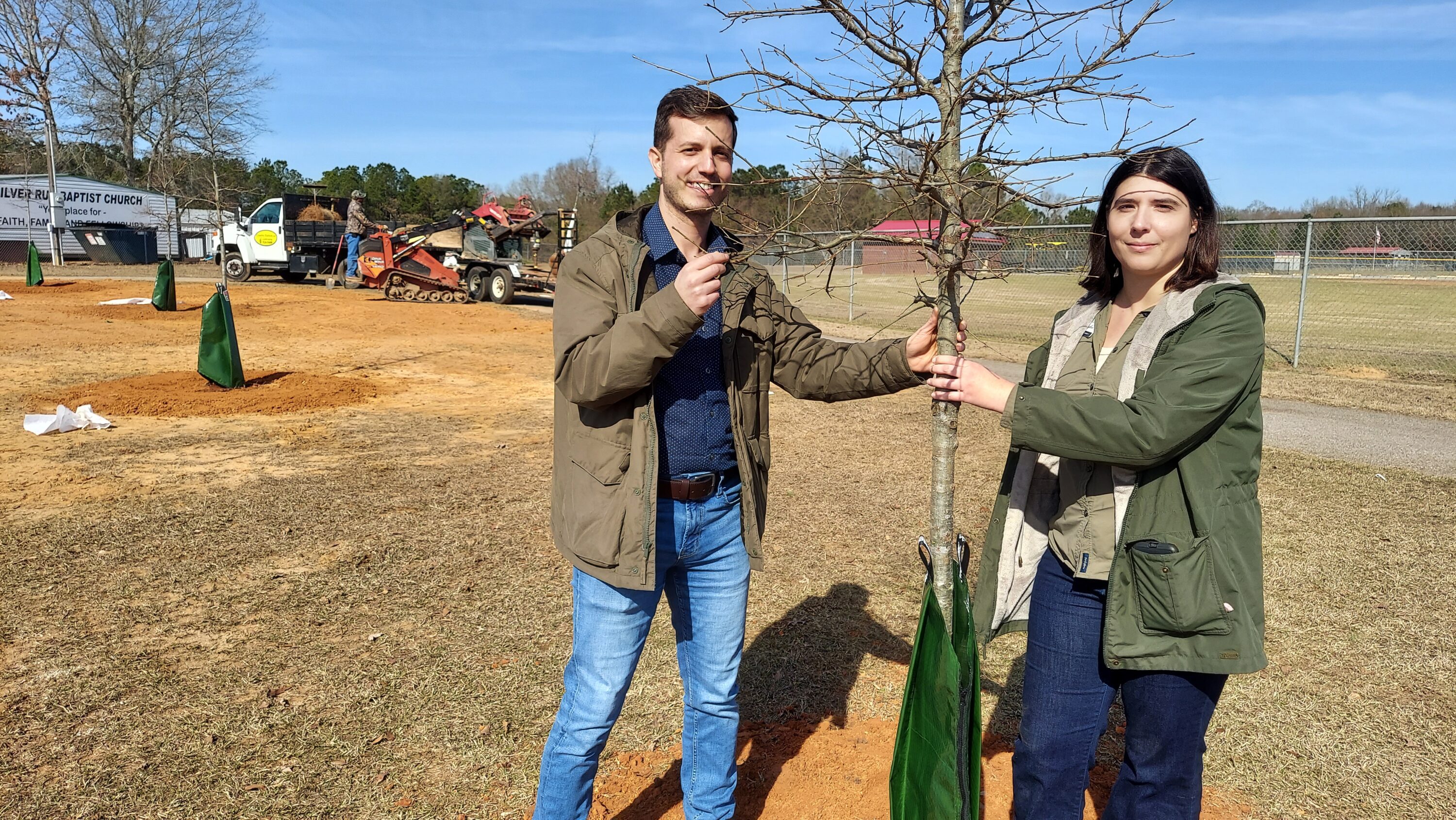 Alabama Extension Specialist Georgios Arseniou, left, and Project Coordinator Jessica Baldwin inspect one of the nuttall oaks planted in Seale, Alabama, on Jan. 20.