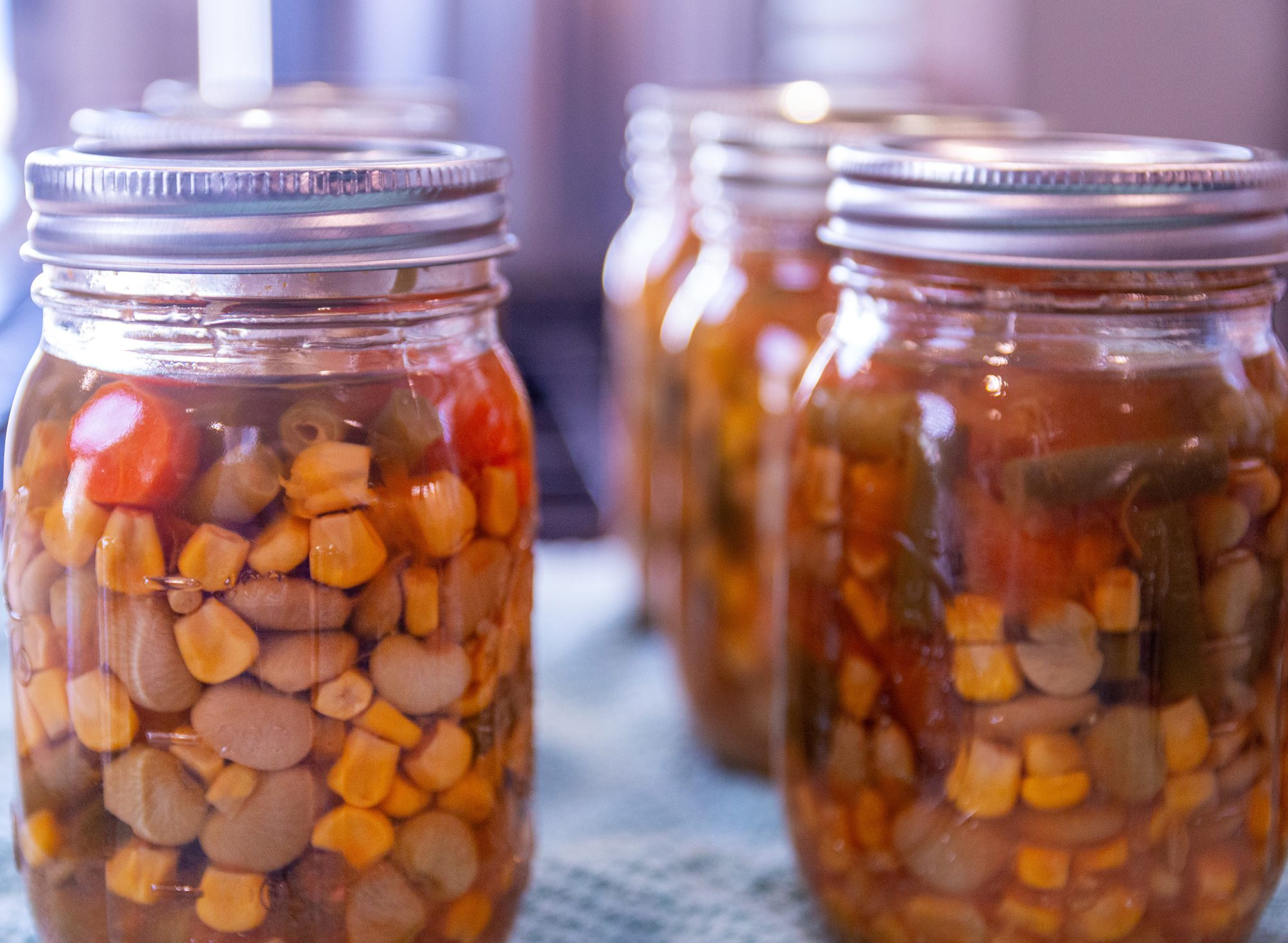 Clear jars of home-canned vegetable soup.