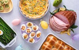 An overhead image of a table with Easter decorations and food, including ham and eggs.