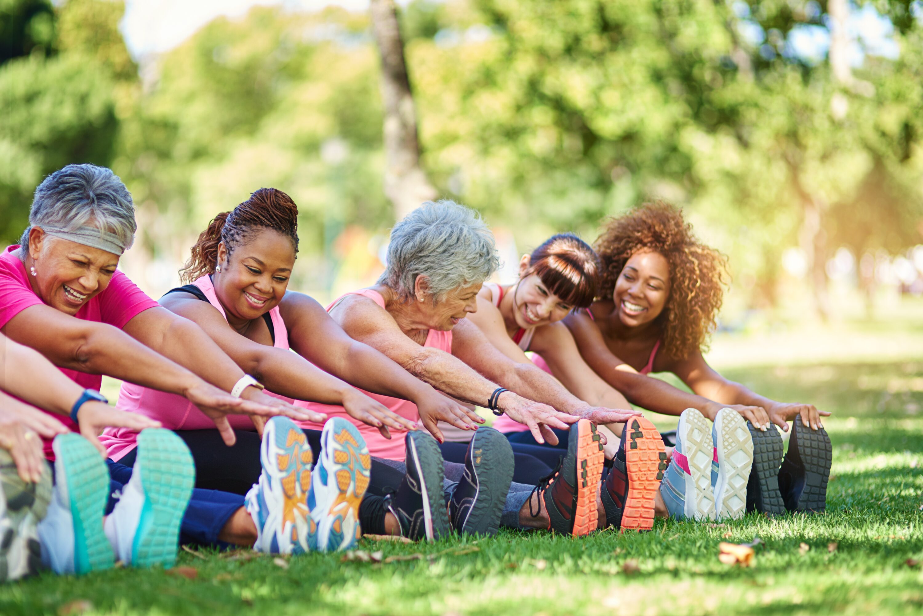 Women in park stretching for fitness.