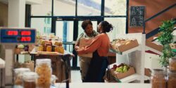 Two women standing and talking in a small-business grocery store.