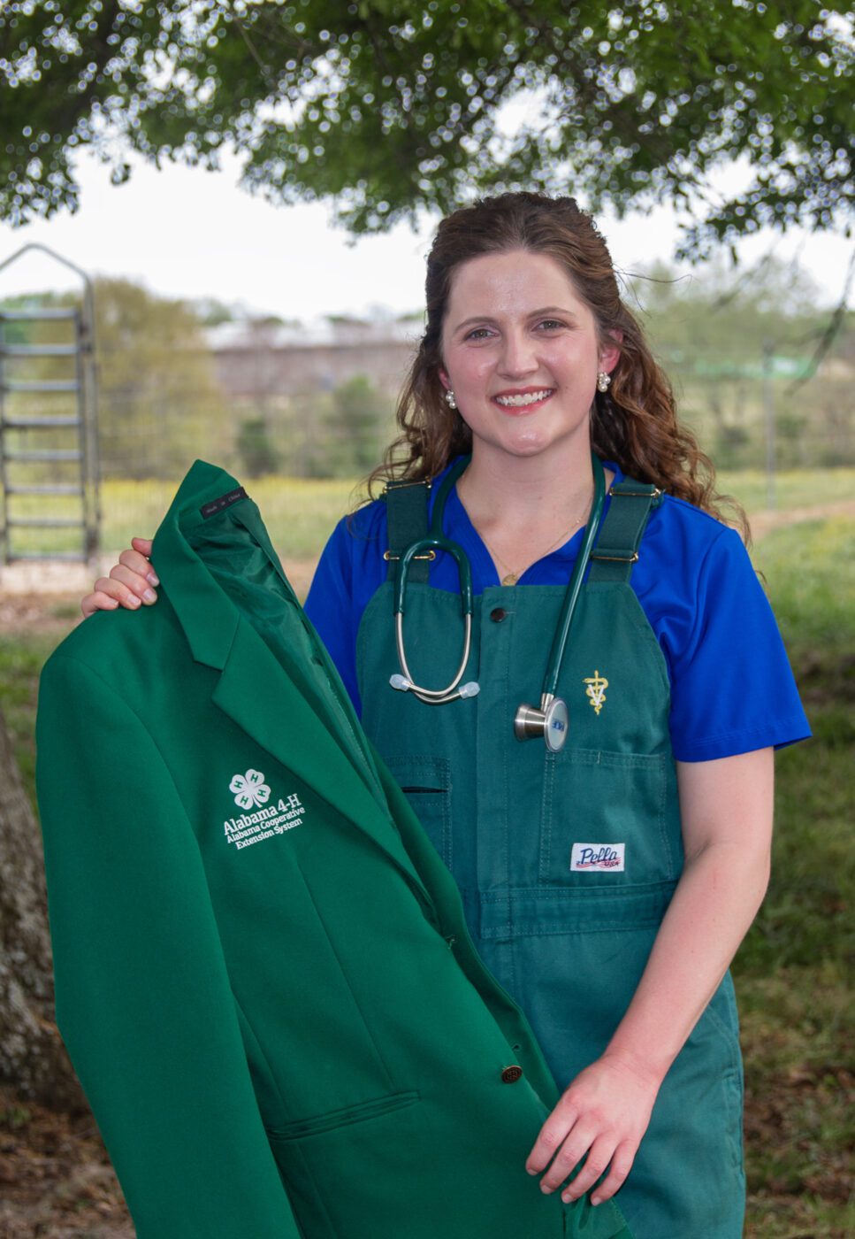 Kaleigh Backstrom holding her State 4-H Ambassador jacket,