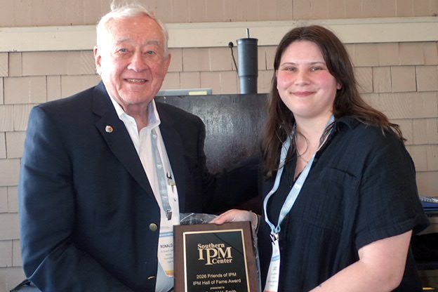 Ron Smith accepting his IPM Hall of Fame Award from Lacy Belanger with the Southern IPM Center.