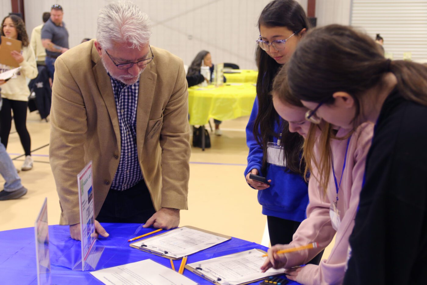 Students talking to a volunteer at one of the Your Money, Your Life booths.