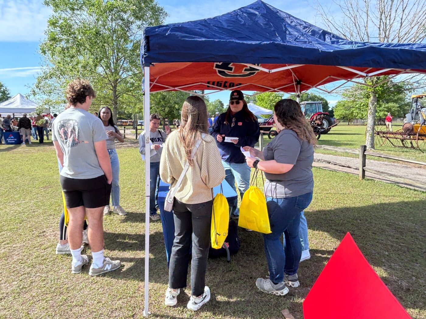 Students stand under at tent talking to a volunteer at one of the 35 vendor stations.