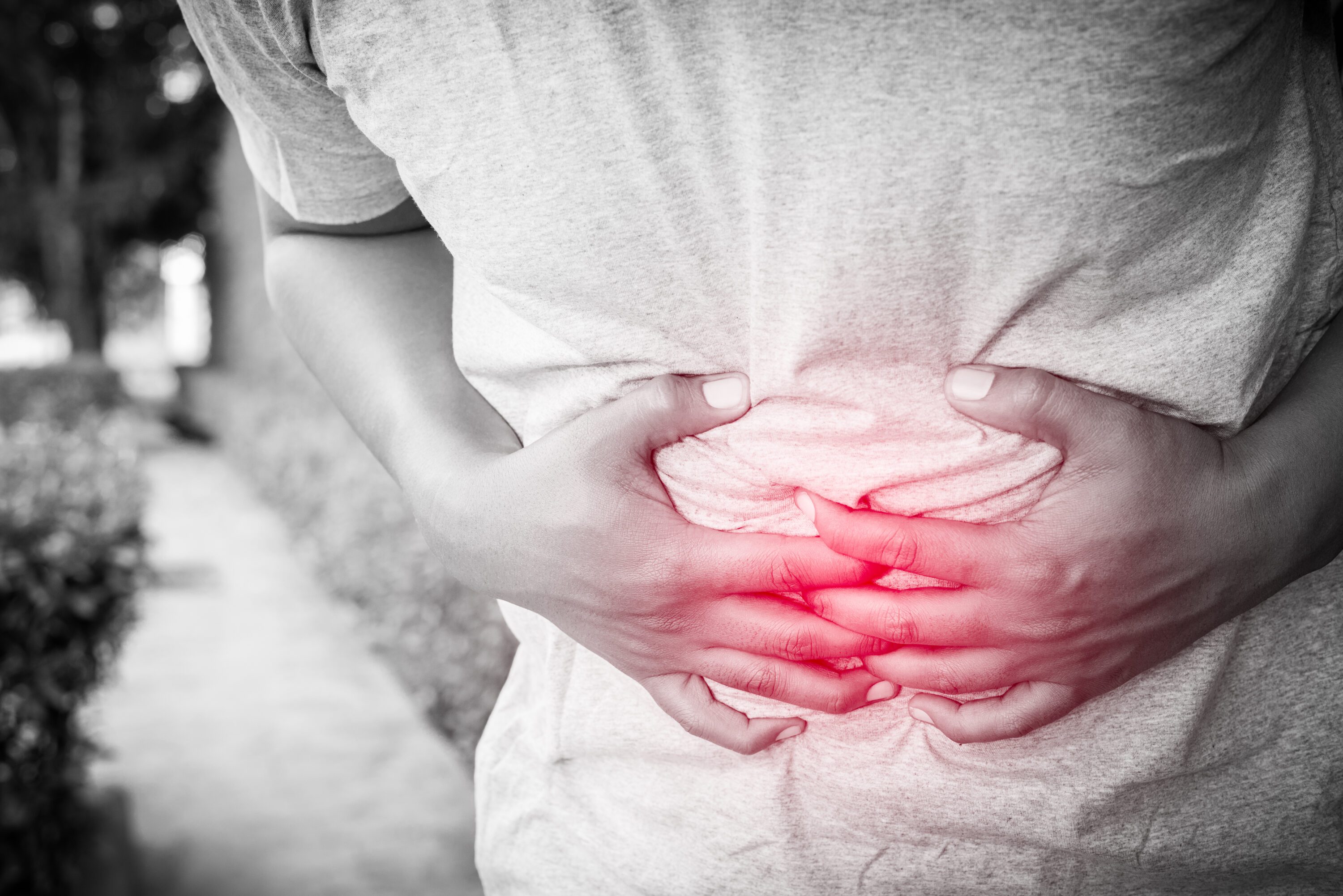 A young man holding his stomach as he was feeling sick.
