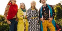 Happy elderly people laughing while standing together in a park.
