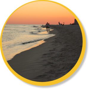 A beach and ocean scene at sunset.