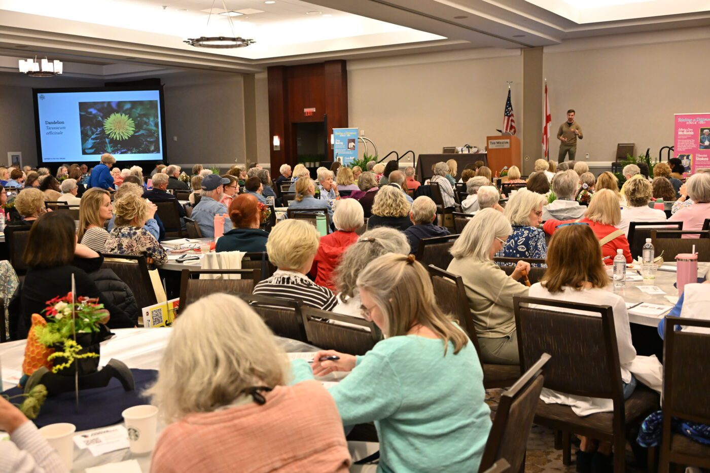 A room full of people listening to a presentation about gardening.