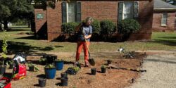 Woman with shovel digging hole in garden. Photo used to promote Master Gardener fall course.