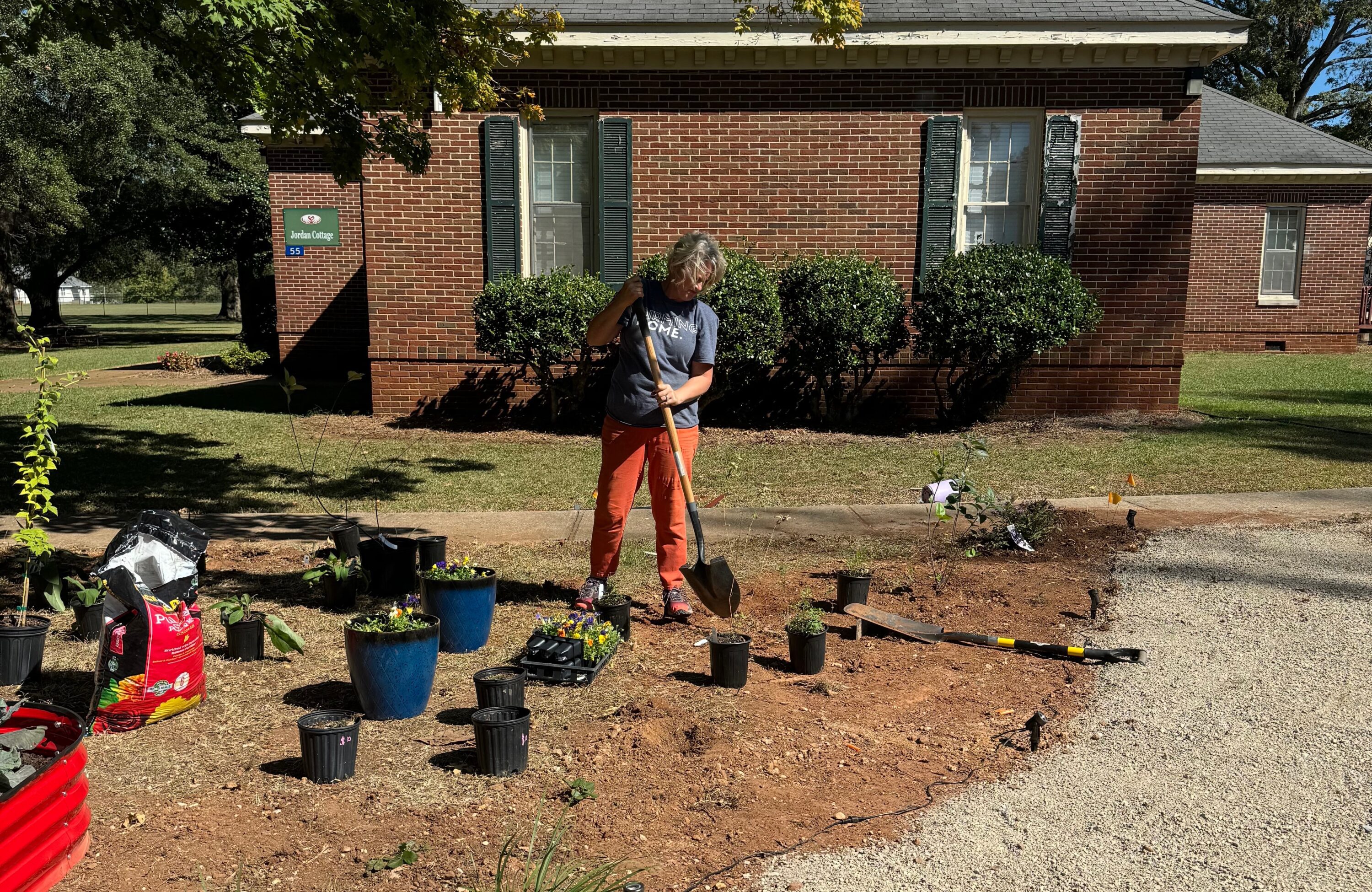 Woman with shovel digging hole in garden. Photo used to promote Master Gardener fall course.