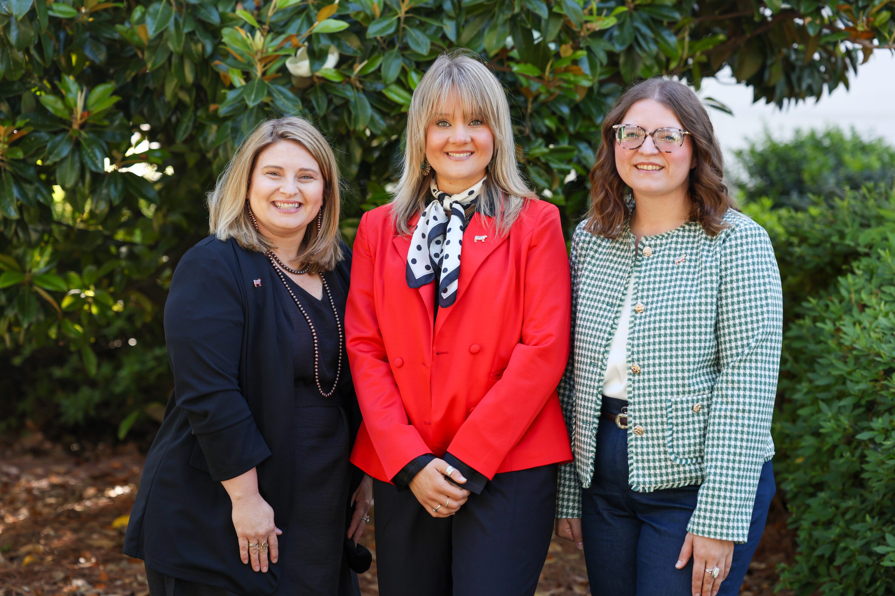 Courtney Heritage, Holly Hall and Maggie Justice standing together outdoors.