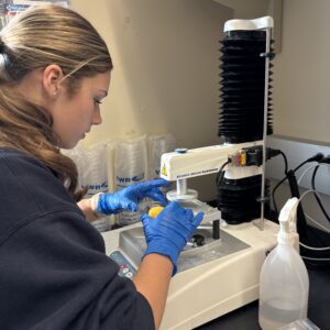 A 4-H member working in a lab to collect data related to poultry science.