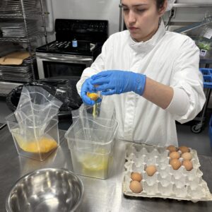 A 4-H member working in a lab to collect data related to poultry science.