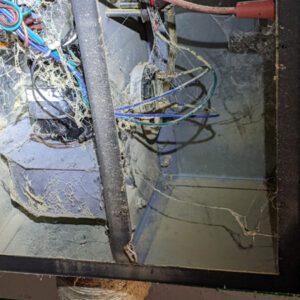 Figure 2A. The inside of the burner box is filled with dust and spider webs.