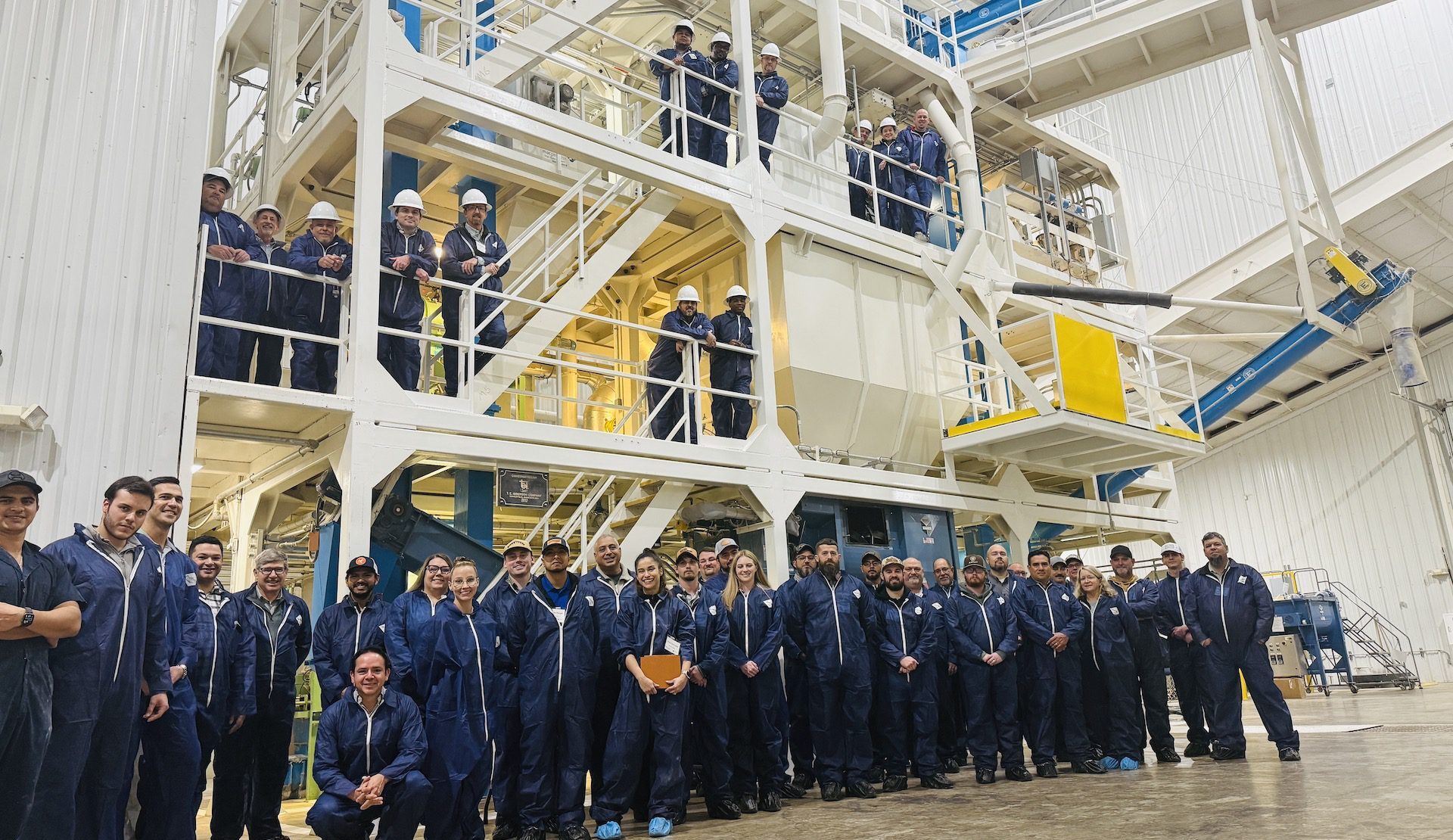 Figure 3. Feed milling workshop participants below and on the feed mill equipment inside the Auburn University Feed Mill.