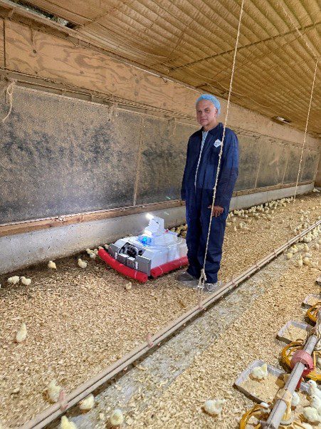 Figure 7. Alabama Extension Specialist Bill Dozier demonstrates an Avirobot inside a broiler house.