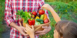 A Farmer And A Child Are Holding A Harvest to celebrate grow more give more