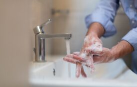 Man using soap and washing hands under the water tap. Hygiene concept hand closeup detail.