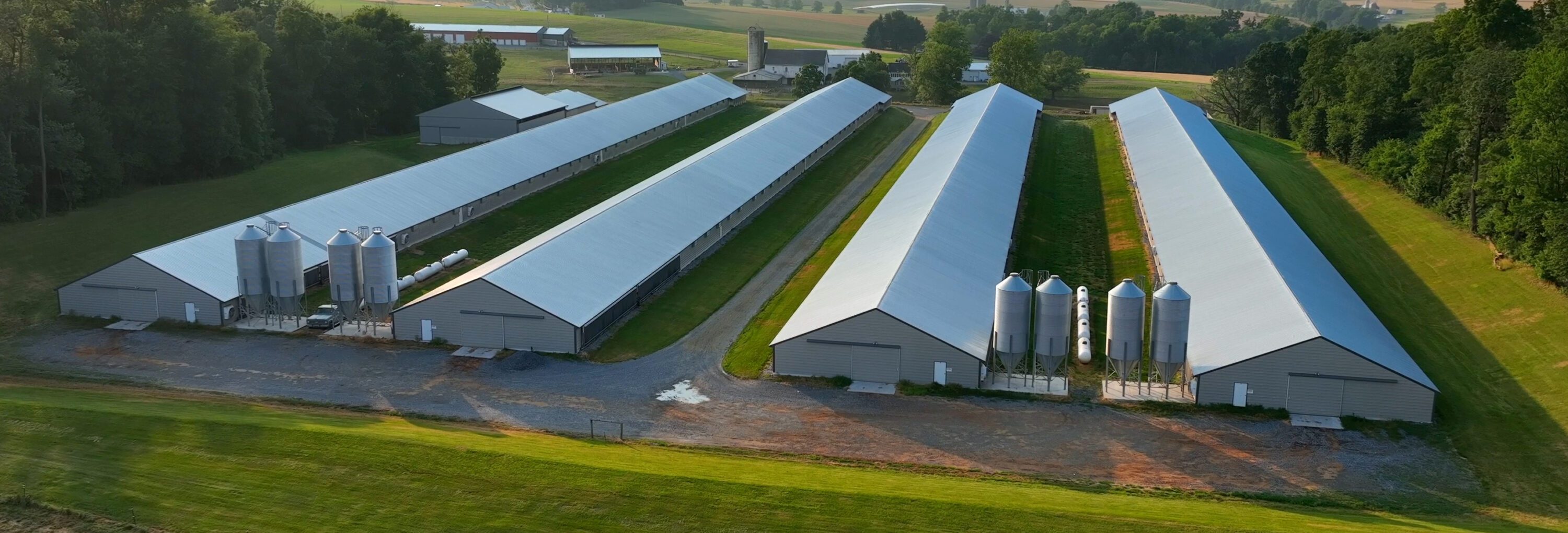 An aerial view of four commercial poultry houses.
