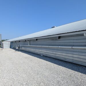 A picture of gutters on the side of a poultry house used to collect rainwater.